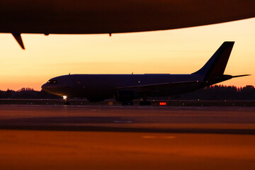 Landing plane during beautiful sunset at airport