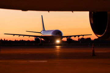 Landing plane during beautiful sunset at airport