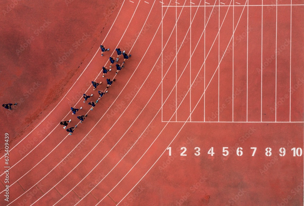 Wall mural aerial view of a running track with a group of runners.