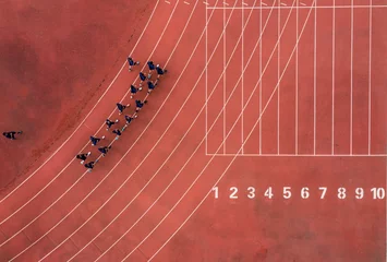 Fototapete Eisenbahnlinie Aerial view of a running track with a group of runners.  © Wirestock