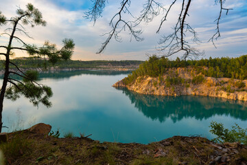 A lake with turquoise water on a sunny summer day with clouds in the sky