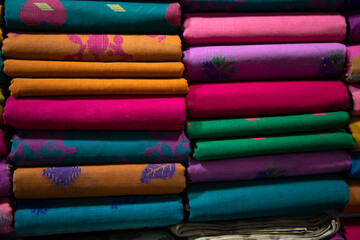 Artistic variety shade tone colors Saree's stacked on retail Shop Shelf to sale