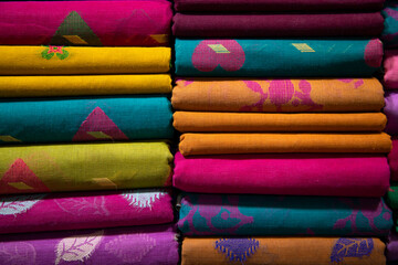 Artistic variety shade tone colors Saree's stacked on retail Shop Shelf to sale