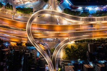 an aerial view of a intersection at night with cars moving