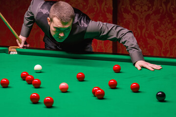 A focused snooker player demonstrating skill and precision during a competitive game