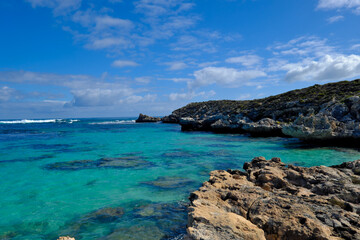 Fototapeta na wymiar Scenic view of a rocky coastline in the ocean against a bright blue sky