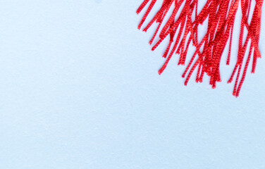 Close up of a red tassel skirt on white board. Festive decorative art.