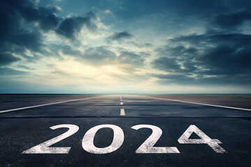 2024 New Year Beginning Concept: '2024' Written on a Straight Asphalt Road to Mountain Horizon with Sunset Mountain Background. Beautiful Evening with Copy Space for Text, Banner, or Poster