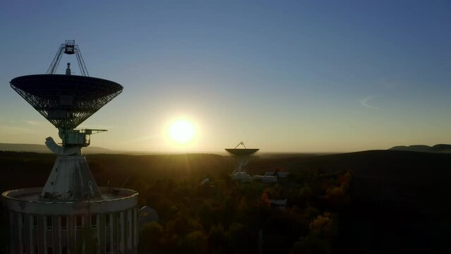 Aerial drone view of telecommunications antenna or Radio telescope satellite dish on sunset