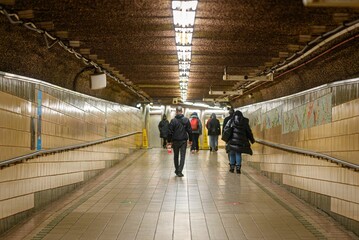 Group of people walking down an underground subway station, New York