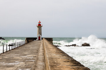 Felgueiras Lighthouse in Porto on the Atlantic coast with huge waves in a sunny day, splashing...