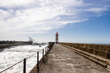 Felgueiras Lighthouse in Porto on the Atlantic coast with huge waves in a sunny day, splashing waves at Farol de Felgueiras