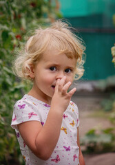 A beautiful girl looks at the camera and picks her nose.