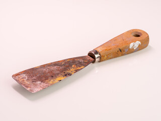 dirty and rusty putty knife after renovation, tool on white background, plastering walls