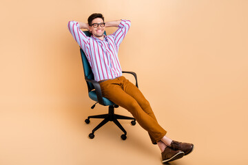 Photo of attractive cheerful man successful chief sit chair hold arms behind head enjoy free time...