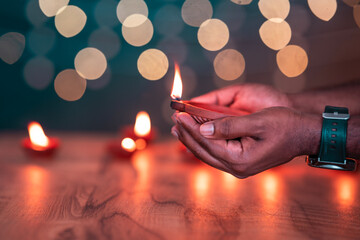Hand holding Diya lamp during Diwali festival