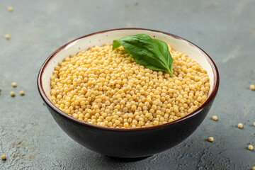 ptitim pasta in bowl on a light background top view. copy space