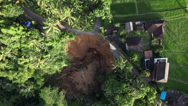 Mediocre landslide of steep slope destroyed road going along top edge of ravine. Buildings and rice paddies are in danger of collapse. The site is not yet stable, landslip has increased