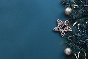 Side border of Christmas frame made of fir branches, golden decorative stars, balls on blue...