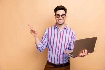 Photo of young businessman wearing striped shirt hold netbook and pointing finger mockup hp...