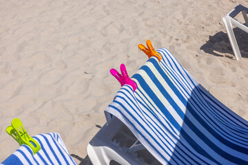 Close up view of Miami's sandy beach with sun loungers topped with beach towels and secured by...