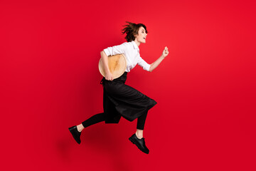 Full body profile side photo of brown bob haired woman jump up run order hurry hold tray isolated on red color background