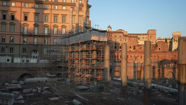 Restoration of ruins of Roman forum. Reconstruction of antique column inside Roman forum. Column surrounded by modern metal scaffolding. Concept of restoration historic cultural landmarks, slow motion