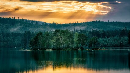 Breathtaking view of a majestic mountain illuminated by a golden sunset, with dramatic dark clouds © Wirestock