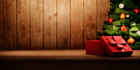 Red christmas present on vintage wooden table and christmas tree with lights. Cozy magic xmas and...