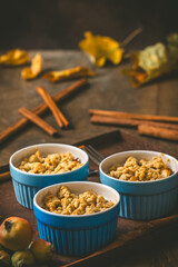 Apple crumble in small molds on dark wood