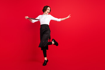 Full body photo of attractive funny young woman dance hold tray good mood isolated on red color background