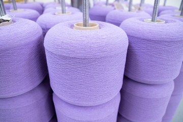 large bobbins of linen threads for lilac - colored fabrics .Flax processing plant, fabric...