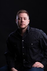 Obraz premium Strict and stylish Man in black shirt on dark background.