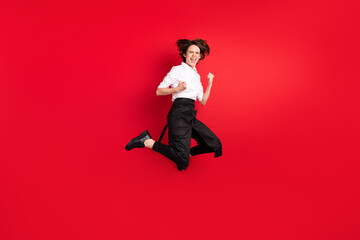 Fototapeta na wymiar Full body photo of charming excited crazy young woman jump up winner hostess isolated on red color background