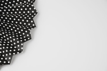 a black and white polka dot dress lying down on a table © Wirestock