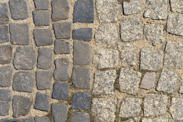 The road is paved with square granite stones.