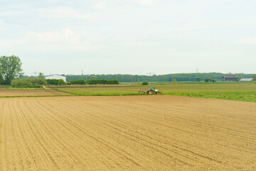 Fototapeta na wymiar A tractor with plows stands near a plowed field.