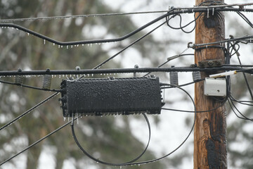 Utility pole and wires covered in ice and frozen rain