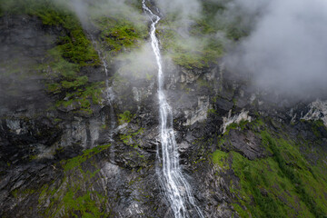 Obraz premium Aerial view of waterfall flowing down cliff into Fjord in Norway