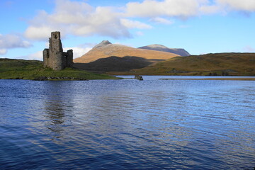 Fototapeta na wymiar The Ruin of 16th Century Ardvreck Castle sat on a Rocky Promontory in Loch Assynt, Sutherland, Scotland with Glas Bheinn (776m) behind.