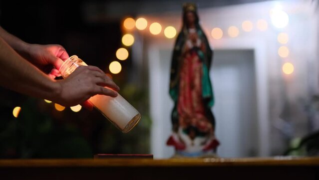 hands of a man lighting candle for Virgen de Guadalupe. Mexican catholic tradition