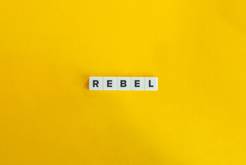 Rebel Word on Letter Tiles on Yellow Background. Minimal Aesthetic.