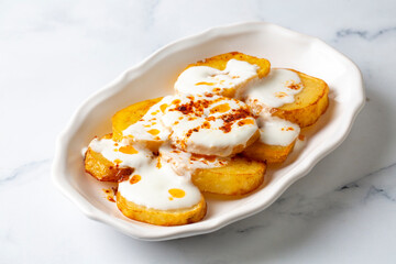 From Turkish cuisine; french fries potatoes with yoghurt sauce. Turkish name; Yogurtlu patates