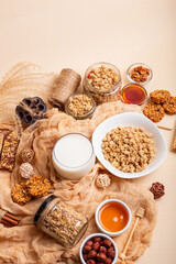 Breakfast idea. Granola with milk. Granola bars, muesli, nuts, honey and glass of milk in rustic...