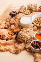 Breakfast idea. Granola with milk. Granola bars, muesli, nuts, honey and glass of milk in rustic...