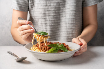 Woman Eating delicious plate of spaghetti with bolognese sauce