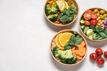 Takeaway food salads Buddha bowl in round cardboard containers. Mediterranean, with broccoli and quinoa, kale and chickpeas bowls. Top view on white background