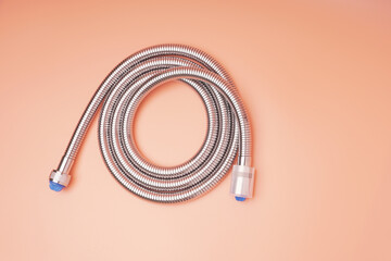Metal shower hose with plugs pink background