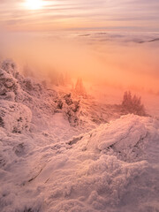 Scenic landscape with a view from a mounatin range to the valley filled with low clouds and fog during temperature inversion