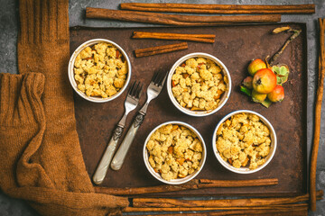 Apple crumble in small molds on a rusty tray